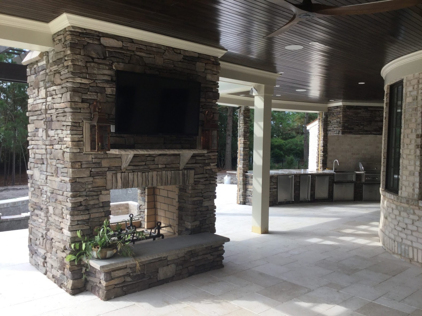 Outdoor stone fireplace and kitchen under covered patio in Wilmington NC